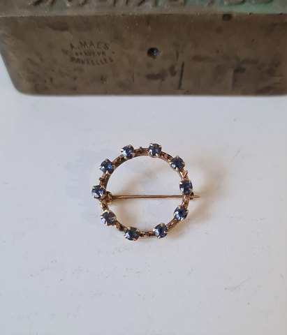 Brooch in 14 kt gold adorned with 10 blue sapphires