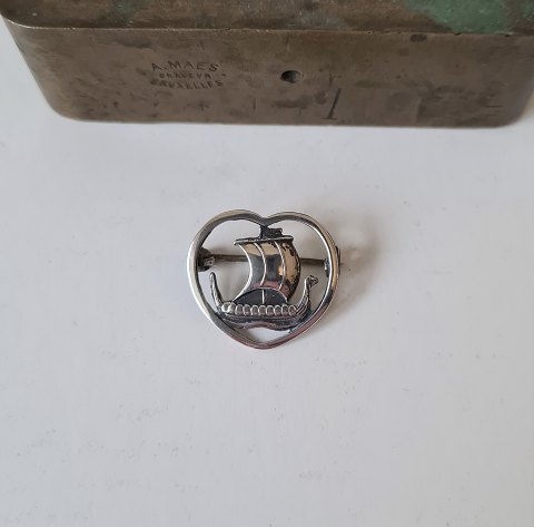 Silver brooch in the shape of a heart with a Viking ship