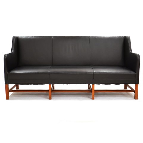Kaare Klint three-seater sofa 5011 upholstered in 
black leather. Manufactured by Rud. Rasmussen. The 
black leather is in a good condition and the frame 
with minor signs of use. H: 92cm. L: 194cm. D: 
65cm