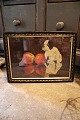 Decorative, old oil painting with a motif of a small dog sitting on a table with 
2 apples...