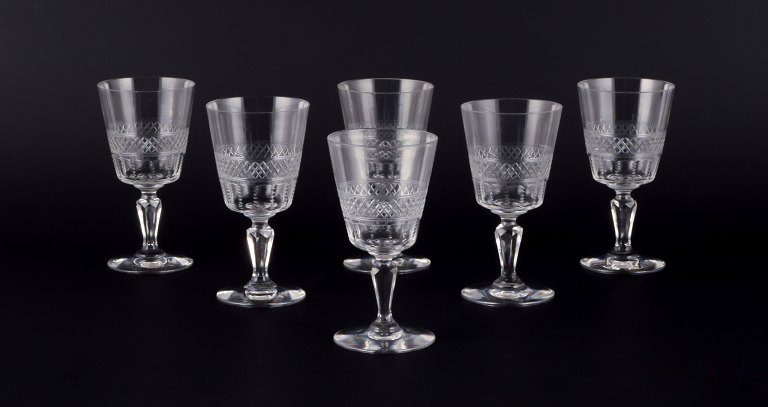 A set of six mouth-blown French white wine glasses in crystal glass. Faceted cut.