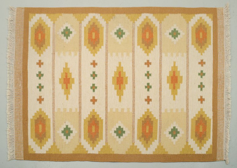 Swedish handwoven carpet in pure wool. Rölakan technique. Ochre yellow, orange, green, and white colors in a geometric pattern.