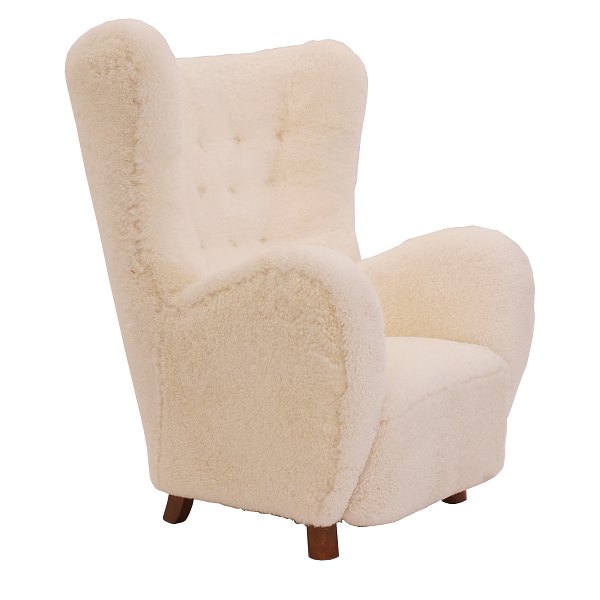 Upholstered high-back lounge chair appears with new sheepskin upholstery.Denmark ca. 1935-40.H: 107cm. W: 81cm